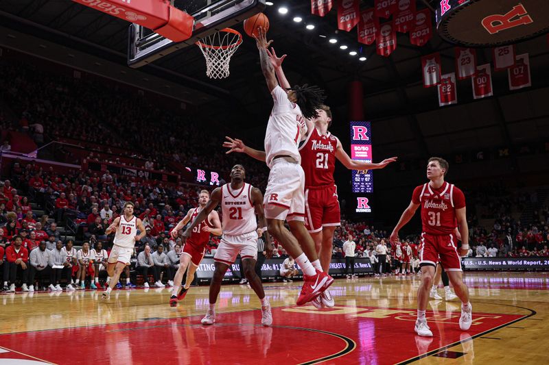 Feb 7, 2026; Piscataway, New Jersey, USA; Rutgers Scarlet Knights guard Jamichael Davis (1) goes to the basket against Nebraska Cornhuskers forward Pryce Sandfort (21) during the second half at Jersey Mike's Arena. Mandatory Credit: Vincent Carchietta-Imagn Images