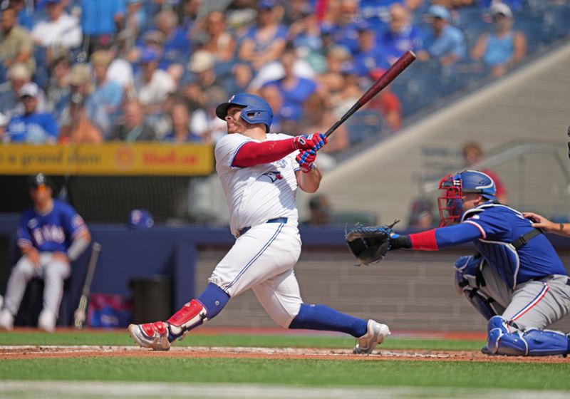 Jul 27, 2024; Toronto, Ontario, CAN; Toronto Blue Jays catcher Alejandro Kirk (30) hits a single against the Texas Rangers during the first inning at Rogers Centre. Mandatory Credit: Nick Turchiaro-USA TODAY Sports