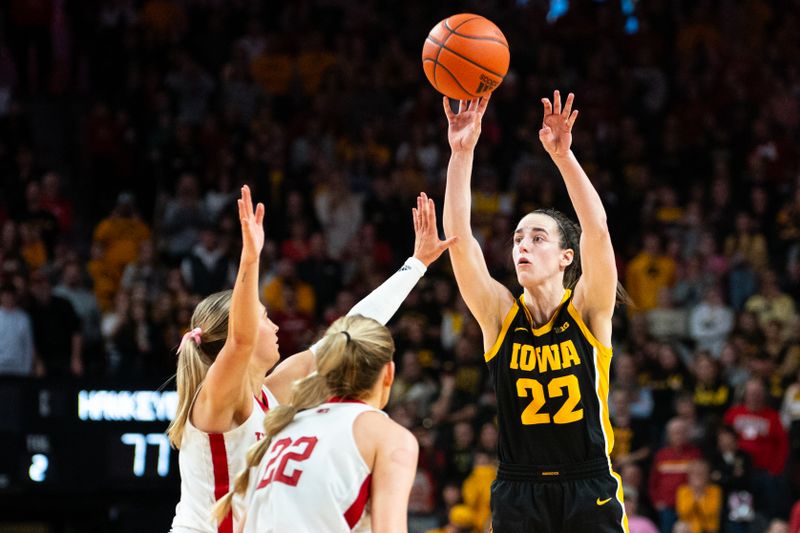 Feb 11, 2024; Lincoln, Nebraska, USA; Iowa Hawkeyes guard Caitlin Clark (22) shoots a three point shot against Nebraska Cornhuskers guard Jaz Shelley (1) and forward Natalie Potts (22) during the fourth quarter at Pinnacle Bank Arena. Mandatory Credit: Dylan Widger-USA TODAY Sports