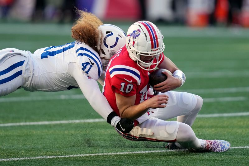 New England Patriots quarterback Drake Maye (10) slides on a carry against Indianapolis Colts linebacker Grant Stuard (41) during the second half of an NFL football game, Sunday, Dec. 1, 2024, in Foxborough, Mass. (AP Photo/Charles Krupa)