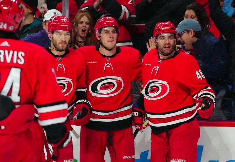 Jan 11, 2024; Raleigh, North Carolina, USA; Carolina Hurricanes defenseman Brady Skjei (76) celebrates his goal with defenseman Brett Pesce (22) and left wing Jordan Martinook (48) against the Anaheim Ducks during the first period at PNC Arena. Mandatory Credit: James Guillory-USA TODAY Sports