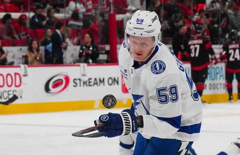 Oct 11, 2024; Raleigh, North Carolina, USA;  Tampa Bay Lightning center Jake Guentzel (59) bouches the puck on his stick before the game against the Carolina Hurricanes at PNC Arena. Mandatory Credit: James Guillory-Imagn Images