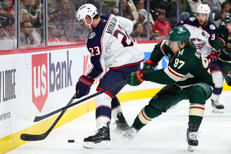 Oct 10, 2024; Saint Paul, Minnesota, USA; Columbus Blue Jackets center Sean Monahan (23) and Minnesota Wild left wing Kirill Kaprizov (97) compete for the puck during the second period at Xcel Energy Center. Mandatory Credit: Matt Krohn-Imagn Images