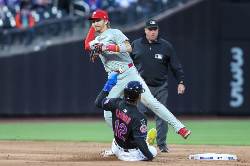 Apr 22, 2025; New York City, New York, USA;  Philadelphia Phillies second baseman Bryson Stott (5) throws past New York Mets shortstop Francisco Lindor (12) attempting to complete a double play in the first inning at Citi Field. Mandatory Credit: Wendell Cruz-Imagn Images