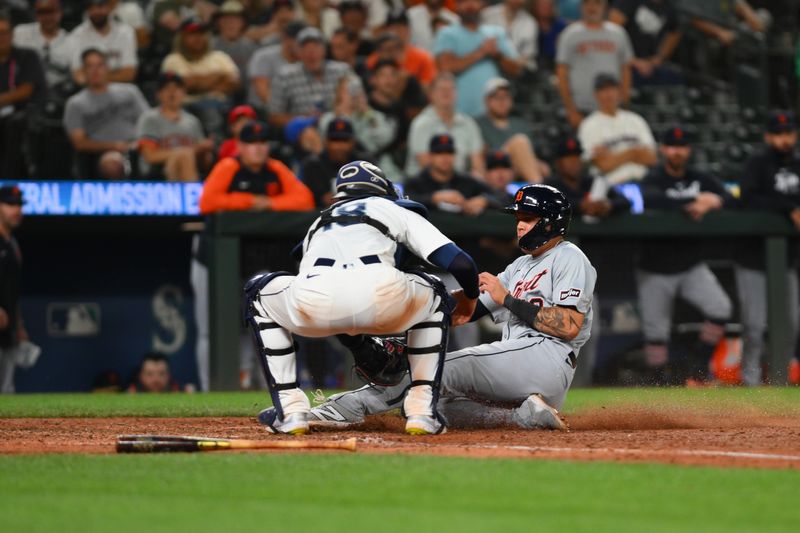 Aug 7, 2024; Seattle, Washington, USA; Detroit Tigers third baseman Gio Urshela (13) is tagged out at home plate by Seattle Mariners catcher Mitch Garver (18) during the ninth inning at T-Mobile Park. Mandatory Credit: Steven Bisig-USA TODAY Sports