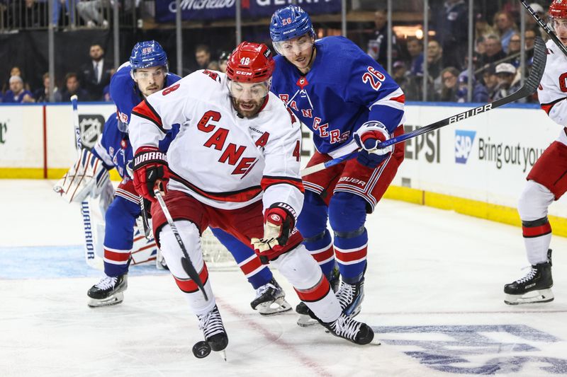 May 5, 2024; New York, New York, USA; Carolina Hurricanes left wing Jordan Martinook (48) and New York Rangers left wing Jimmy Vesey (26) battle for control of the puck in the third period in game one of the second round of the 2024 Stanley Cup Playoffs at Madison Square Garden. Mandatory Credit: Wendell Cruz-USA TODAY Sports