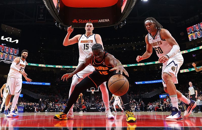 ATLANTA, GEORGIA - DECEMBER 11:  Clint Capela #15 of the Atlanta Hawks reaches for a loose ball against Aaron Gordon #50 and Nikola Jokic #15 of the Denver Nuggets during the first half at State Farm Arena on December 11, 2023 in Atlanta, Georgia.  NOTE TO USER: User expressly acknowledges and agrees that, by downloading and/or using this photograph, user is consenting to the terms and conditions of the Getty Images License Agreement.  (Photo by Kevin C. Cox/Getty Images)