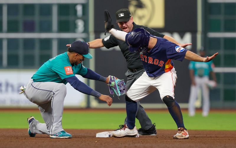 Sep 21, 2025; Houston, Texas, USA; Second base umpire Mike Muchlinski (76) calls Houston Astros second baseman Jose Altuve (27) safe at second base against Seattle Mariners second baseman Jorge Polanco (7) in the fifth inning at Daikin Park. Mandatory Credit: Thomas Shea-Imagn Images