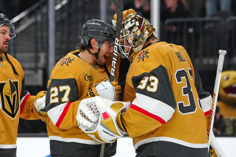 Nov 29, 2024; Las Vegas, Nevada, USA; Vegas Golden Knights goaltender Adin Hill (33) celebrates with defenseman Shea Theodore (27) after defeating the Winnipeg Jets 4-3 at T-Mobile Arena. Mandatory Credit: Stephen R. Sylvanie-Imagn Images