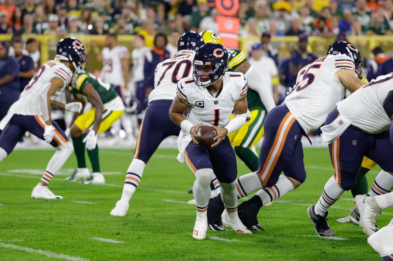 Chicago Bears quarterback Justin Fields hands the ball off during an NFL football game against the Green Bay Packers Sunday, Sept. 18, 2022, in Green Bay, Wis. (AP Photo/Matt Ludtke)