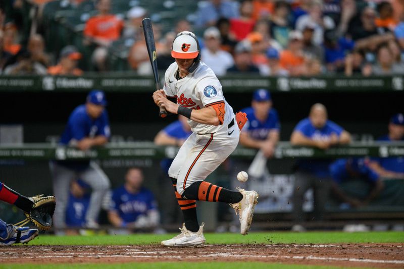 Jun 30, 2024; Baltimore, Maryland, USA; Baltimore Orioles outfielder Austin Hays (21) is hit by a pitch during the fifth inning against the Texas Rangers at Oriole Park at Camden Yards. Mandatory Credit: Reggie Hildred-USA TODAY Sports