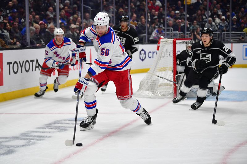 Jan 20, 2024; Los Angeles, California, USA; New York Rangers left wing Will Cuylle (50) moves the puck ahead of Los Angeles Kings defenseman Jordan Spence (21) durng the first period at Crypto.com Arena. Mandatory Credit: Gary A. Vasquez-USA TODAY Sports