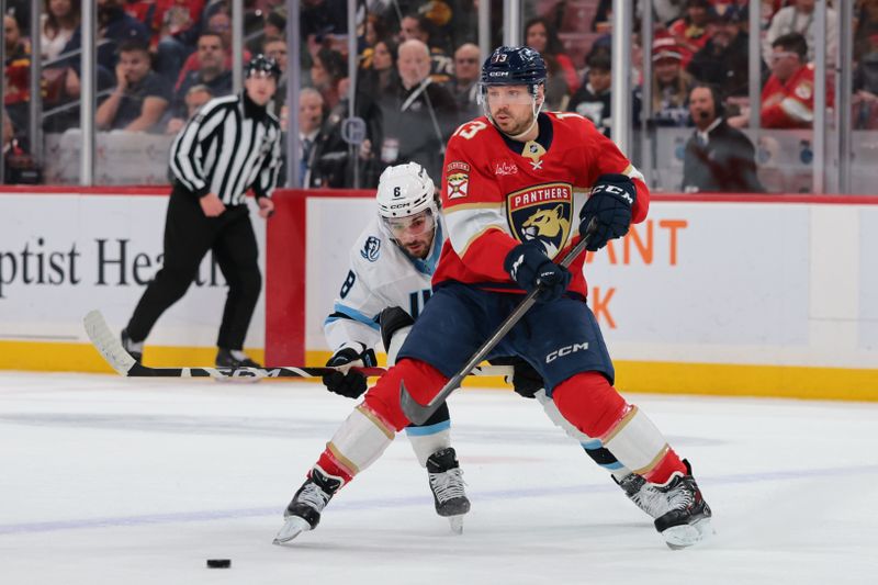 Jan 27, 2026; Sunrise, Florida, USA; Florida Panthers center Sam Reinhart (13) moves the puck against Utah Mammoth center Nick Schmaltz (8) during the first period at Amerant Bank Arena. Mandatory Credit: Sam Navarro-Imagn Images