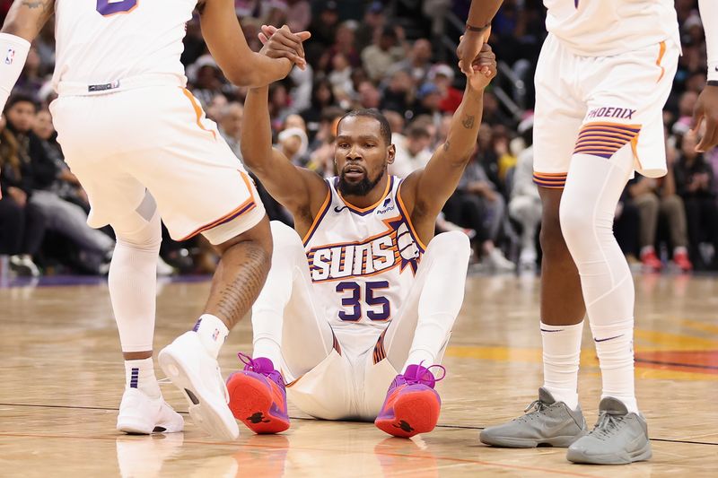 PHOENIX, ARIZONA - DECEMBER 25: Kevin Durant #35 of the Phoenix Suns is helped up by teammates during the second half of the NBA game at Footprint Center on December 25, 2023 in Phoenix, Arizona. The Mavericks defeated the Suns 128-114. NOTE TO USER: User expressly acknowledges and agrees that, by downloading and or using this photograph, User is consenting to the terms and conditions of the Getty Images License Agreement.  (Photo by Christian Petersen/Getty Images)