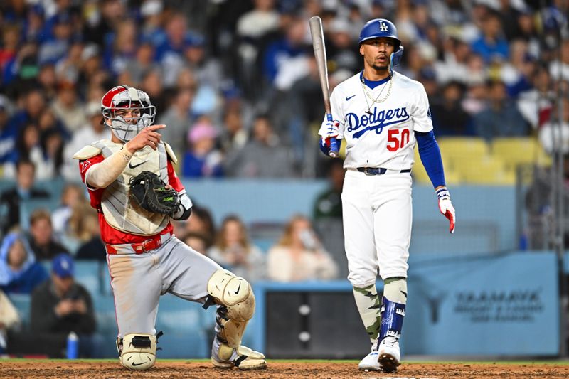 May 17, 2025; Los Angeles, California, USA; Los Angeles Angels catcher Logan O'Hoppe (14) points against Los Angeles Dodgers shortstop Mookie Betts (50) during the sixth inning at Dodger Stadium. Mandatory Credit: Jonathan Hui-Imagn Images