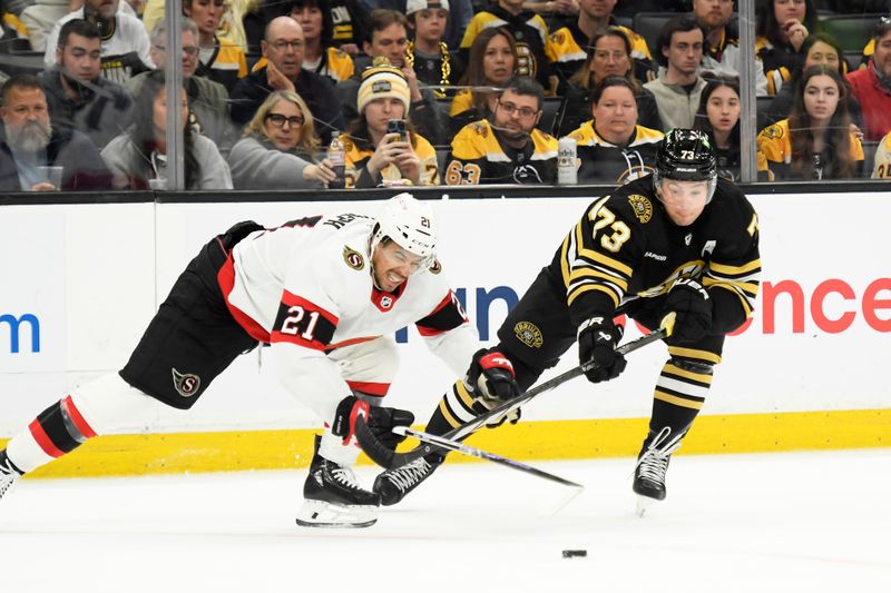 Apr 16, 2024; Boston, Massachusetts, USA;  Ottawa Senators right wing Mathieu Joseph (21) and Boston Bruins defenseman Charlie McAvoy (73) battle for the puck during the third period at TD Garden. Mandatory Credit: Bob DeChiara-USA TODAY Sports