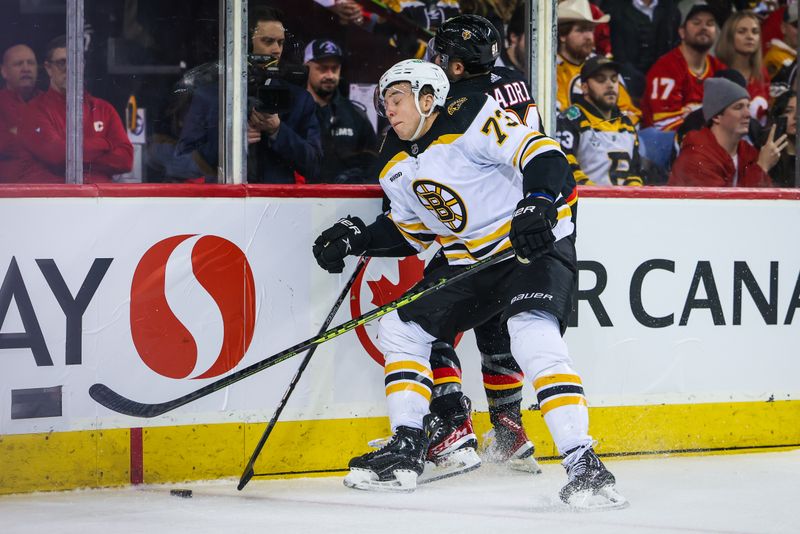 Feb 28, 2023; Calgary, Alberta, CAN; Boston Bruins defenseman Charlie McAvoy (73) and Calgary Flames center Nazem Kadri (91) battle for the puck during the second period at Scotiabank Saddledome. Mandatory Credit: Sergei Belski-USA TODAY Sports