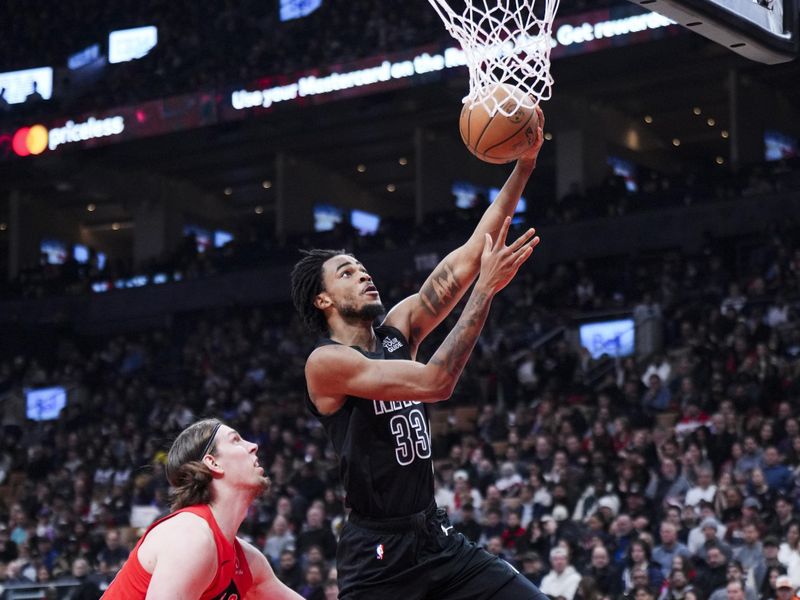 TORONTO, ON - JANUARY 1: Nicolas Claxton #33 of the Brooklyn Nets goes to the basket against Kelly Olynyk #41 of the Toronto Raptors during the first half of their basketball game at the Scotiabank Arena on January 1, 2025 in Toronto, Ontario, Canada. NOTE TO USER: User expressly acknowledges and agrees that, by downloading and/or using this Photograph, user is consenting to the terms and conditions of the Getty Images License Agreement. (Photo by Mark Blinch/Getty Images)