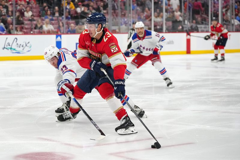 Dec 29, 2023; Sunrise, Florida, USA; New York Rangers defenseman Adam Fox (23) reaches for the puck on Florida Panthers center Carter Verhaeghe (23) during the second period at Amerant Bank Arena. Mandatory Credit: Jasen Vinlove-USA TODAY Sports