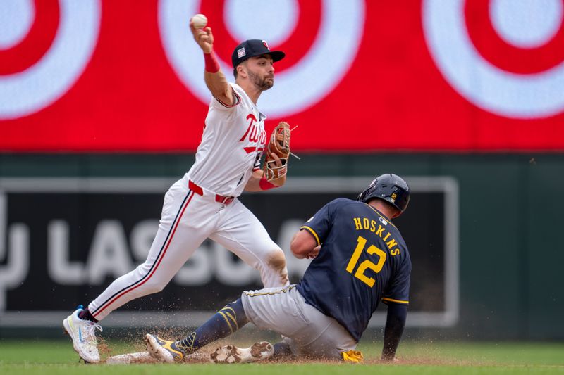 Jul 21, 2024; Minneapolis, Minnesota, USA; Minnesota Twins second base Edouard Julien (47) throws to first after retiring Milwaukee Brewers first base Rhys Hoskins (12) at second base in the fifth inning at Target Field. Mandatory Credit: Matt Blewett-USA TODAY Sports