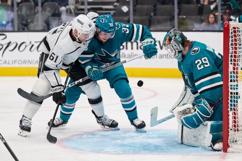 Apr 4, 2024; San Jose, California, USA; Los Angeles Kings center Trevor Lewis (61) vies for the puck against San Jose Sharks defenseman Calen Addison (33) and goaltender Mackenzie Blackwood (29) during the third period at SAP Center at San Jose. Mandatory Credit: Robert Edwards-USA TODAY Sports