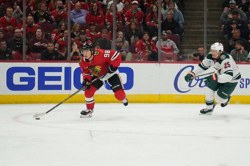 Oct 4, 2024; Chicago, Illinois, USA; Minnesota Wild defenseman Jonas Brodin (25) defends Chicago Blackhawks center Connor Bedard (98) during the first period at United Center. Mandatory Credit: David Banks-Imagn Images