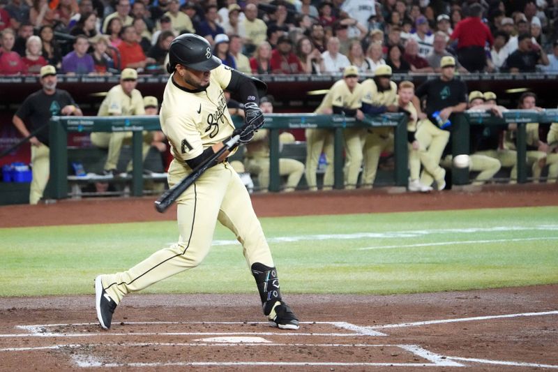 Aug 31, 2024; Phoenix, Arizona, USA; Arizona Diamondbacks outfielder Lourdes Gurriel Jr. (12) hits a ball that drives in two runs against the Los Angeles Dodgers during the first inning at Chase Field. Mandatory Credit: Joe Camporeale-USA TODAY Sports