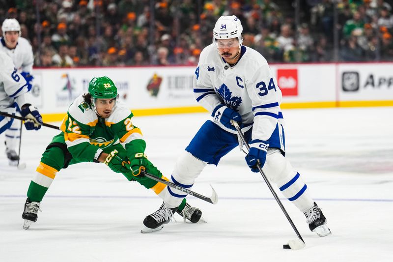 Nov 3, 2024; Saint Paul, Minnesota, USA; Toronto Maple Leafs center Auston Matthews (34) protects the puck from Minnesota Wild center Marat Khusnutdinov (22) during the first period at Xcel Energy Center. Mandatory Credit: Brace Hemmelgarn-Imagn Images