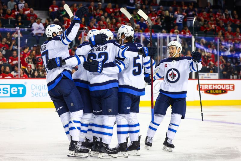 Oct 26, 2024; Calgary, Alberta, CAN; Winnipeg Jets defenseman Dylan Samberg (54) celebrates his goal with teammates against the Calgary Flames during the third period at Scotiabank Saddledome. Mandatory Credit: Sergei Belski-Imagn Images