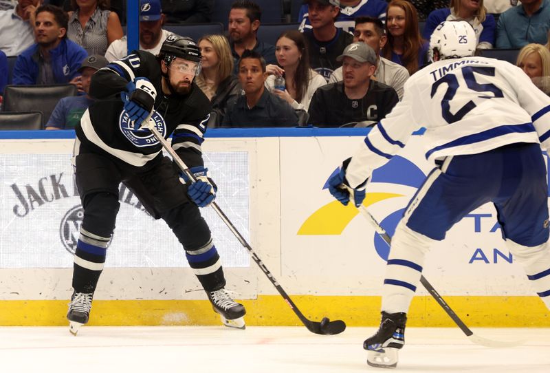 Apr 17, 2024; Tampa, Florida, USA; Tampa Bay Lightning left wing Nicholas Paul (20) passes the puck as Toronto Maple Leafs defenseman Conor Timmins (25) defends during the third period at Amalie Arena. Mandatory Credit: Kim Klement Neitzel-USA TODAY Sports