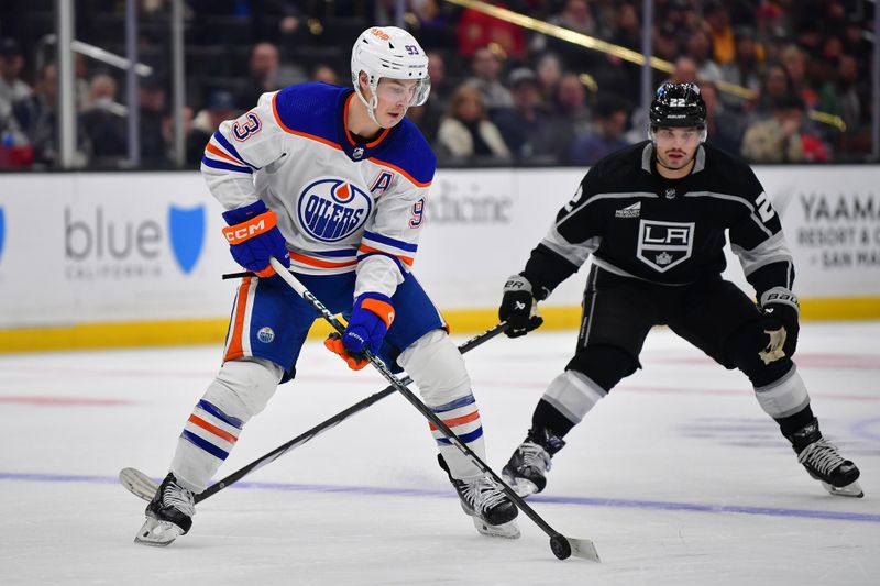 Dec 30, 2023; Los Angeles, California, USA; Edmonton Oilers center Ryan Nugent-Hopkins (93) moves the puck ahead of Los Angeles Kings left wing Kevin Fiala (22) during the second period at Crypto.com Arena. Mandatory Credit: Gary A. Vasquez-USA TODAY Sports