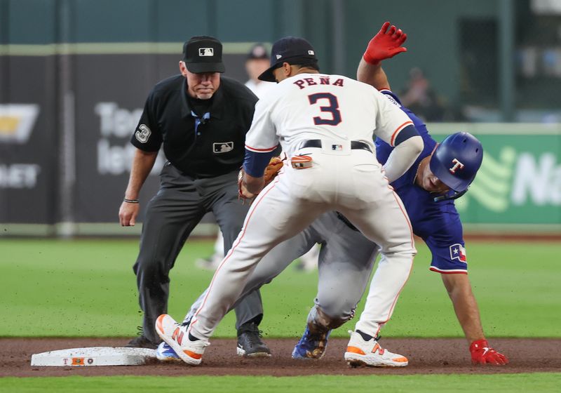 Apr 13, 2024; Houston, Texas, USA;  Texas Rangers designated hitter Wyatt Langford (36) is tagged out by Houston Astros shortstop Jeremy Pena (3) after hitting an RBI single and tying to stretch it out to a double in the first inning at Minute Maid Park. Mandatory Credit: Thomas Shea-USA TODAY Sports