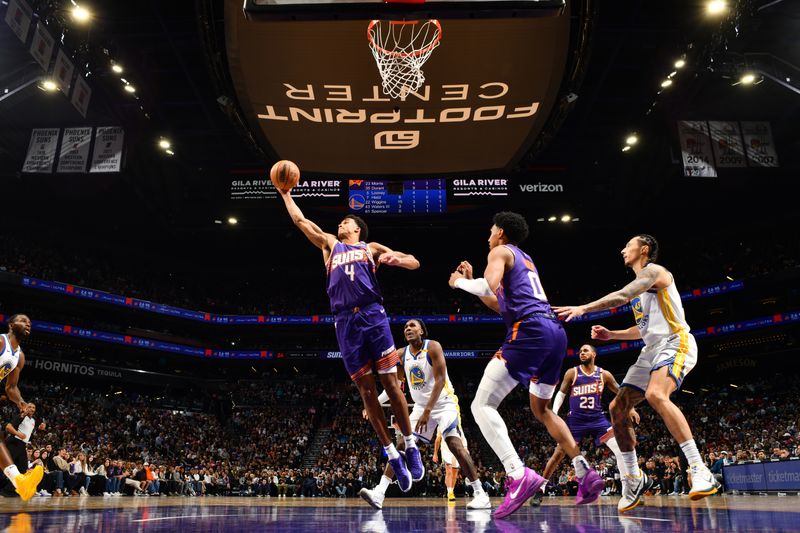 PHOENIX, AZ - NOVEMBER 30: Oso Ighodaro #4 of the Phoenix Suns rebounds the ball during the game against the Golden State Warriors on November 30, 2024 at Footprint Center in Phoenix, Arizona. NOTE TO USER: User expressly acknowledges and agrees that, by downloading and or using this photograph, user is consenting to the terms and conditions of the Getty Images License Agreement. Mandatory Copyright Notice: Copyright 2024 NBAE (Photo by Barry Gossage/NBAE via Getty Images)