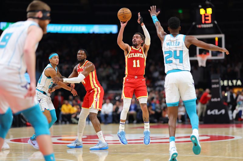 ATLANTA, GEORGIA - APRIL 10:  Trae Young #11 of the Atlanta Hawks shoots a three-point basket against Brandon Miller #24 of the Charlotte Hornets during the second quarter at State Farm Arena on April 10, 2024 in Atlanta, Georgia.  NOTE TO USER: User expressly acknowledges and agrees that, by downloading and/or using this photograph, user is consenting to the terms and conditions of the Getty Images License Agreement.  (Photo by Kevin C. Cox/Getty Images)