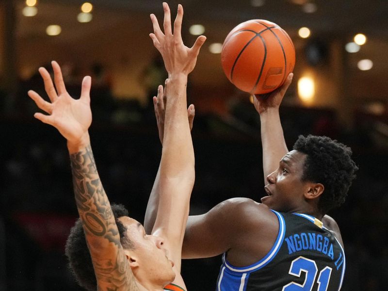 Feb 25, 2025; Coral Gables, Florida, USA;  Duke Blue Devils center Patrick Ngongba II (21) shoots over Miami (Fl) Hurricanes center Lynn Kidd (1) during the first half at Watsco Center. Mandatory Credit: Jim Rassol-Imagn Images