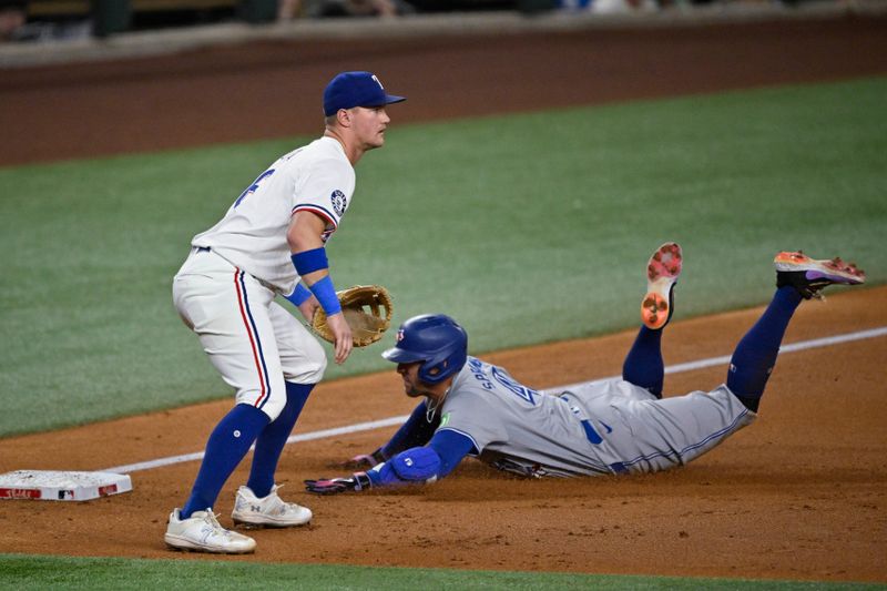 Sep 17, 2024; Arlington, Texas, USA; Toronto Blue Jays right fielder George Springer (4) slides past Texas Rangers third baseman Josh Jung (6) after Springer hits a triple during the second inning at Globe Life Field. Mandatory Credit: Jerome Miron-Imagn Images