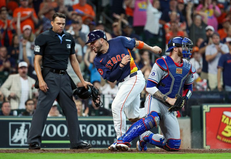 Apr 14, 2024; Houston, Texas, USA; Houston Astros catcher Victor Caratini (17) scores a run past Texas Rangers catcher Jonah Heim (28) during the fourth inning at Minute Maid Park. Mandatory Credit: Troy Taormina-USA TODAY Sports