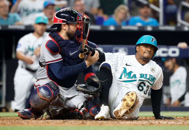 Sep 15, 2023; Miami, Florida, USA; Miami Marlins shortstop Xavier Edwards (63) falls on Atlanta Braves catcher Travis d'Arnaud (16) after being hit by a pitch during the seventh inning at loanDepot Park. Mandatory Credit: Rhona Wise-USA TODAY Sports