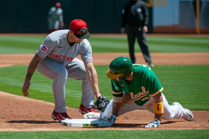 Apr 29, 2023; Oakland, California, USA; Cincinnati Reds third baseman Nick Senzel (15) attempts to tag out Oakland Athletics right fielder Ramon Laureano (22) during the second inning at RingCentral Coliseum. Mandatory Credit: Ed Szczepanski-USA TODAY Sports