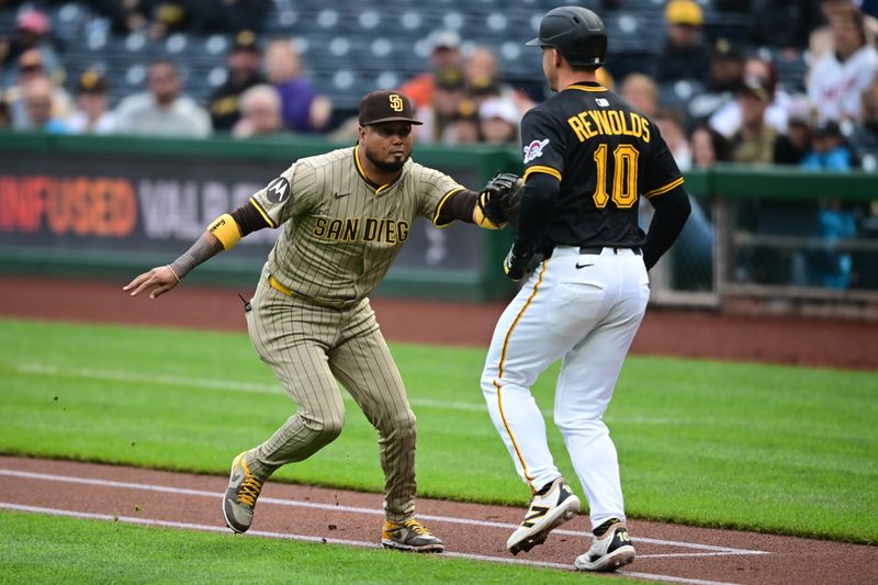 May 3, 2025; Pittsburgh, Pennsylvania, USA; San Diego Padres first baseman Luis Arraez (4) tags out Pittsburgh Pirates right fielder Bryan Reynolds (10) during the first inning at PNC Park. Mandatory Credit: David Dermer-Imagn Images
