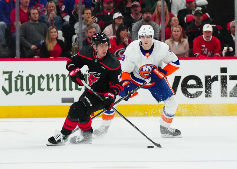 Apr 20, 2024; Raleigh, North Carolina, USA; Carolina Hurricanes center Evgeny Kuznetsov (92) skates with the puck in front of New York Islanders defenseman Alexander Romanov (28) during the second period in game one of the first round of the 2024 Stanley Cup Playoffs at PNC Arena. Mandatory Credit: James Guillory-USA TODAY Sports