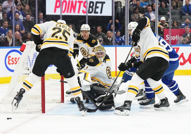 Nov 5, 2024; Toronto, Ontario, CAN; Boston Bruins defenseman Brandon Carlo (25) battles for the loose puck as goaltender Jeremy Swayman (1) looks for the rebound against the Toronto Maple Leafs during the first period at Scotiabank Arena. Mandatory Credit: Nick Turchiaro-Imagn Imagess