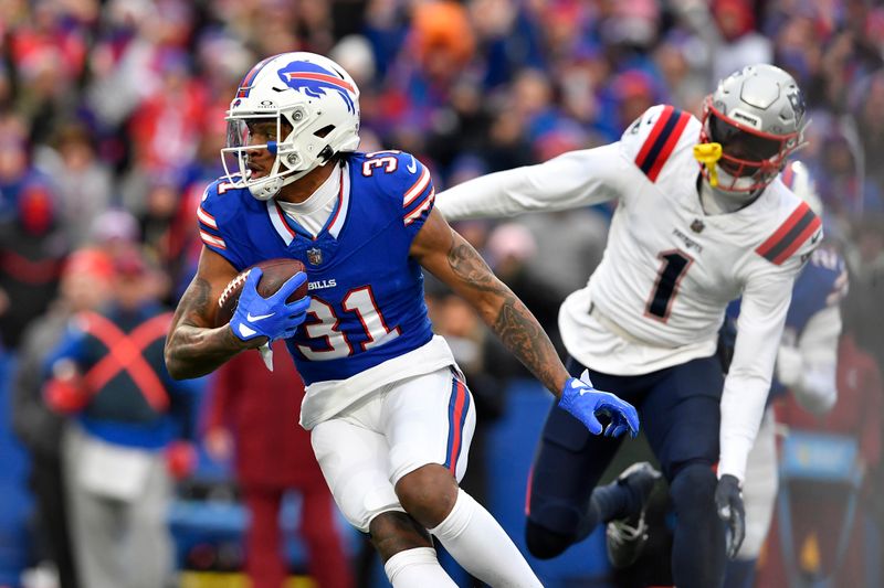 Buffalo Bills cornerback Rasul Douglas (31) runs after intercepting a pass intended for New England Patriots wide receiver DeVante Parker (1) during the first half of an NFL football game in Orchard Park, N.Y., Sunday, Dec. 31, 2023. (AP Photo/Adrian Kraus)