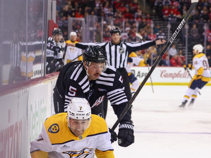 Nov 25, 2024; Newark, New Jersey, USA; New Jersey Devils defenseman Brenden Dillon (5) knocks down Nashville Predators defenseman Marc Del Gaizo (7) during the first period at Prudential Center. Mandatory Credit: Ed Mulholland-Imagn Images