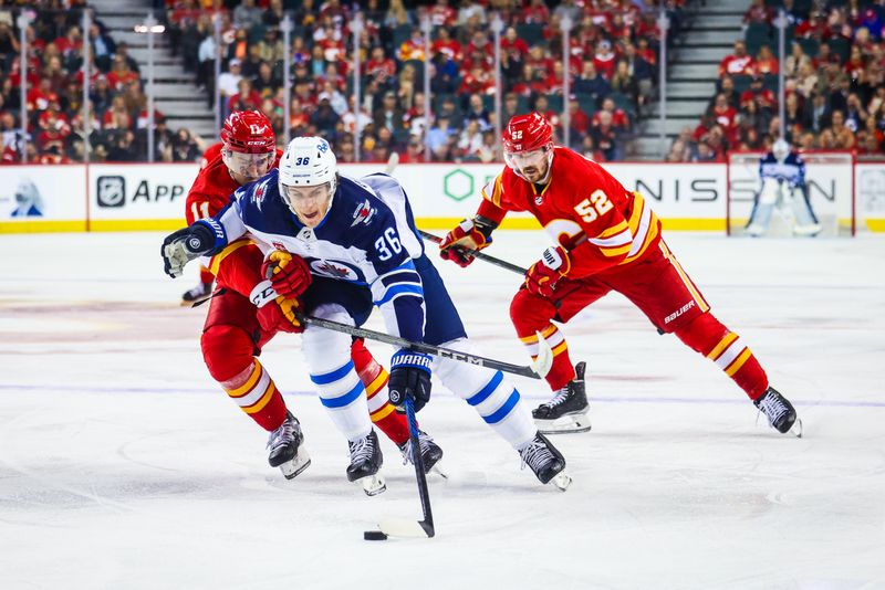 Oct 11, 2023; Calgary, Alberta, CAN; Winnipeg Jets center Morgan Barron (36) and Calgary Flames center Mikael Backlund (11) battle for the puck during the first period at Scotiabank Saddledome. Mandatory Credit: Sergei Belski-USA TODAY Sports