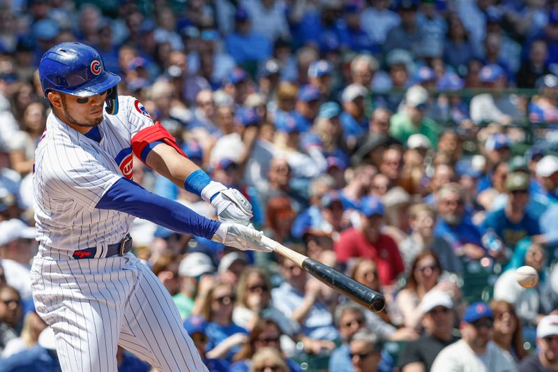 May 5, 2023; Chicago, Illinois, USA; Chicago Cubs right fielder Seiya Suzuki (27) hits an RBI-single against the Miami Marlins during the first inning at Wrigley Field. Mandatory Credit: Kamil Krzaczynski-USA TODAY Sports