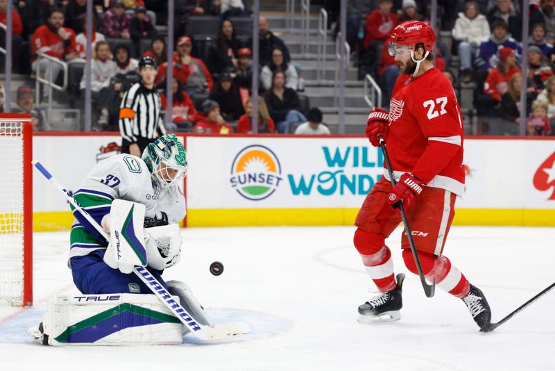 Dec 1, 2024; Detroit, Michigan, USA;  Vancouver Canucks goaltender Kevin Lankinen (32) makes a save in front of Detroit Red Wings center Michael Rasmussen (27) in the second period at Little Caesars Arena. Mandatory Credit: Rick Osentoski-Imagn Images