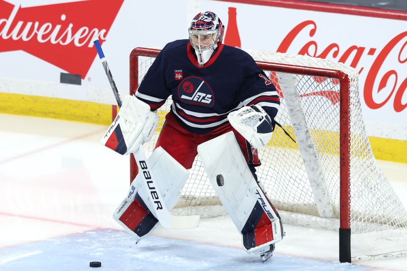 Jan 18, 2025; Winnipeg, Manitoba, CAN; Winnipeg Jets goaltender Eric Comrie (1) warms up before a game against the Calgary Flames at Canada Life Centre. Mandatory Credit: James Carey Lauder-Imagn Images