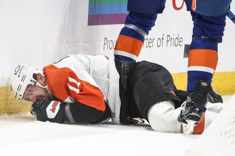 Jan 16, 2025; Elmont, New York, USA;  Philadelphia Flyers right wing Travis Konecny (11) lays on the ice after colliding into the wall in the first period at UBS Arena. Mandatory Credit: Wendell Cruz-Imagn Images