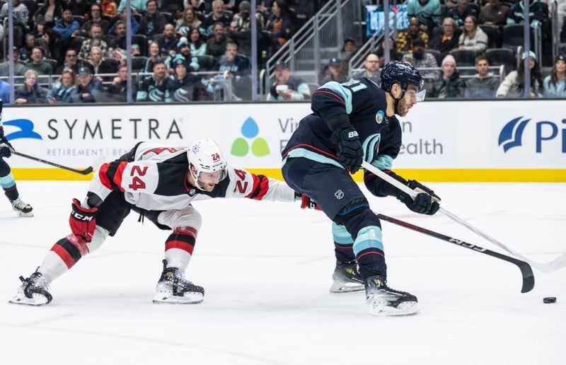 Dec 7, 2023; Seattle, Washington, USA; Seattle Kraken forward Alex Wennberg (21) skates against New Jersey Devils defenseman Colin Miller (24) during the second period at Climate Pledge Arena. Mandatory Credit: Stephen Brashear-USA TODAY Sports